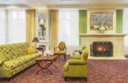 A welcoming living room showcasing a fireplace and a soft couch, perfect for gatherings and leisure time at The Gardens at Town Square.