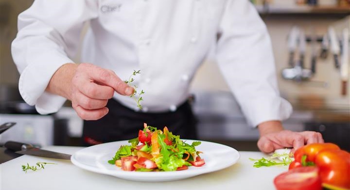 Chef garnishing a colorful salad