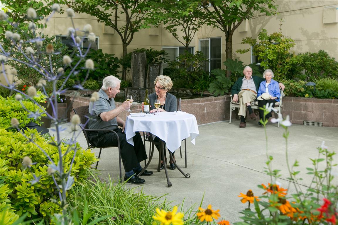 Older couples dining in the garden courtyard on a summer day