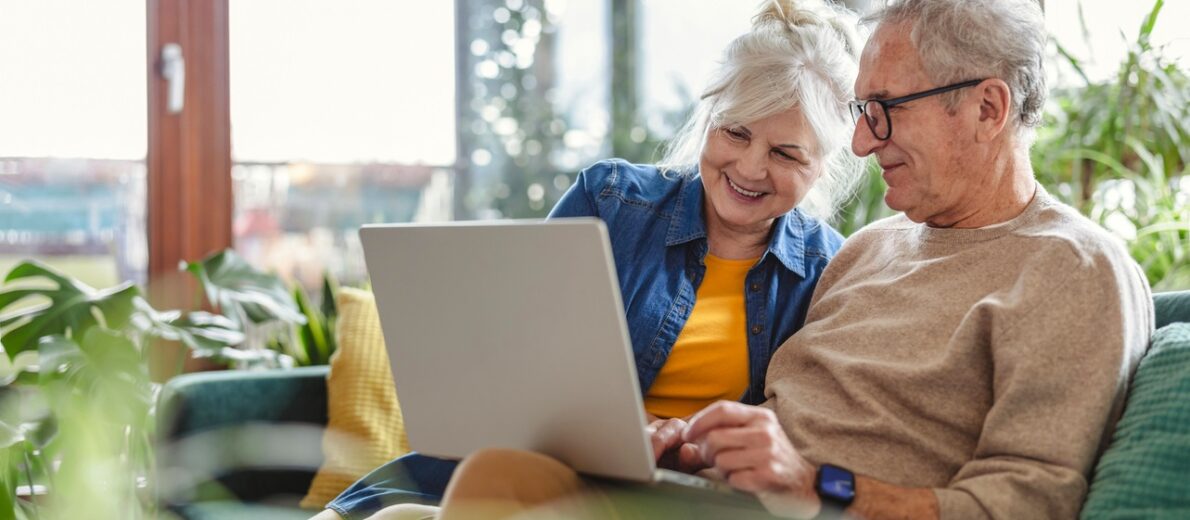 Senior couple evaluating options on laptop