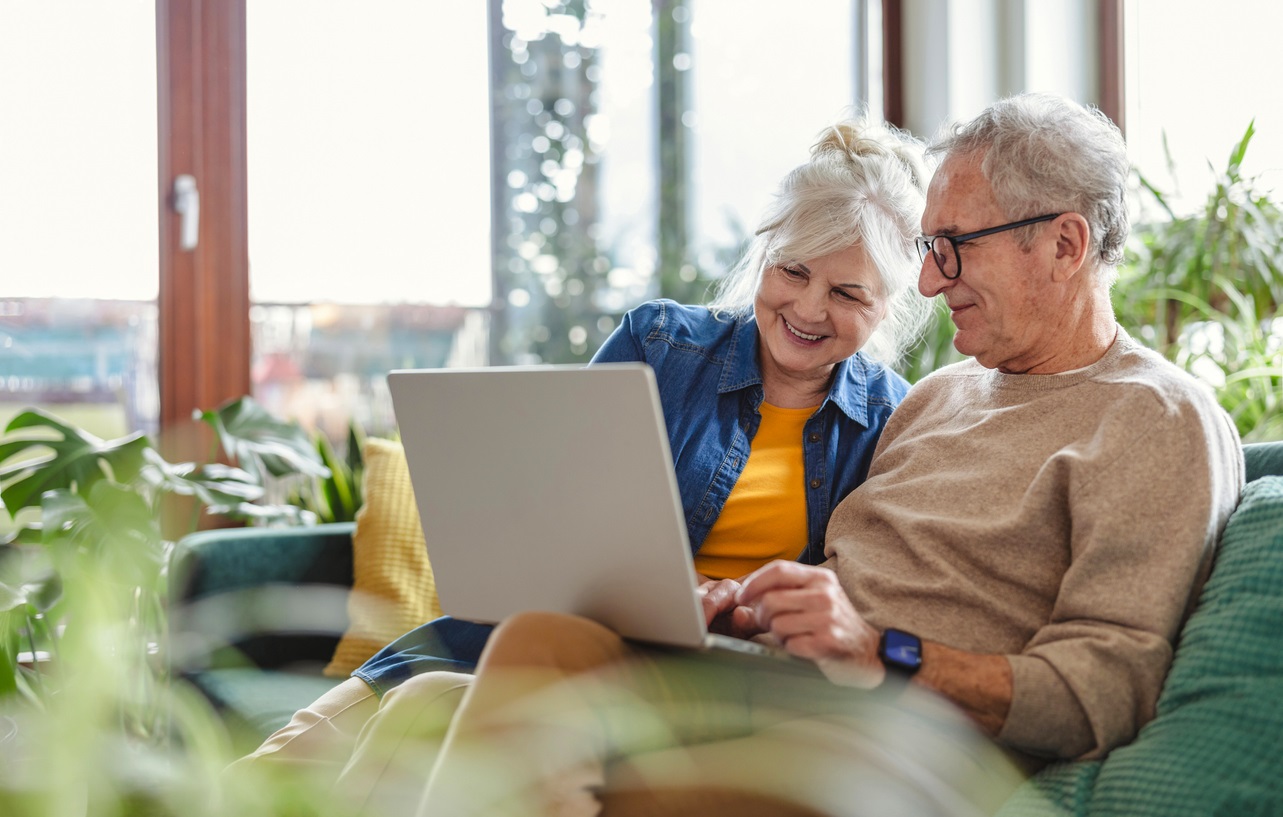 Senior couple evaluating options on laptop