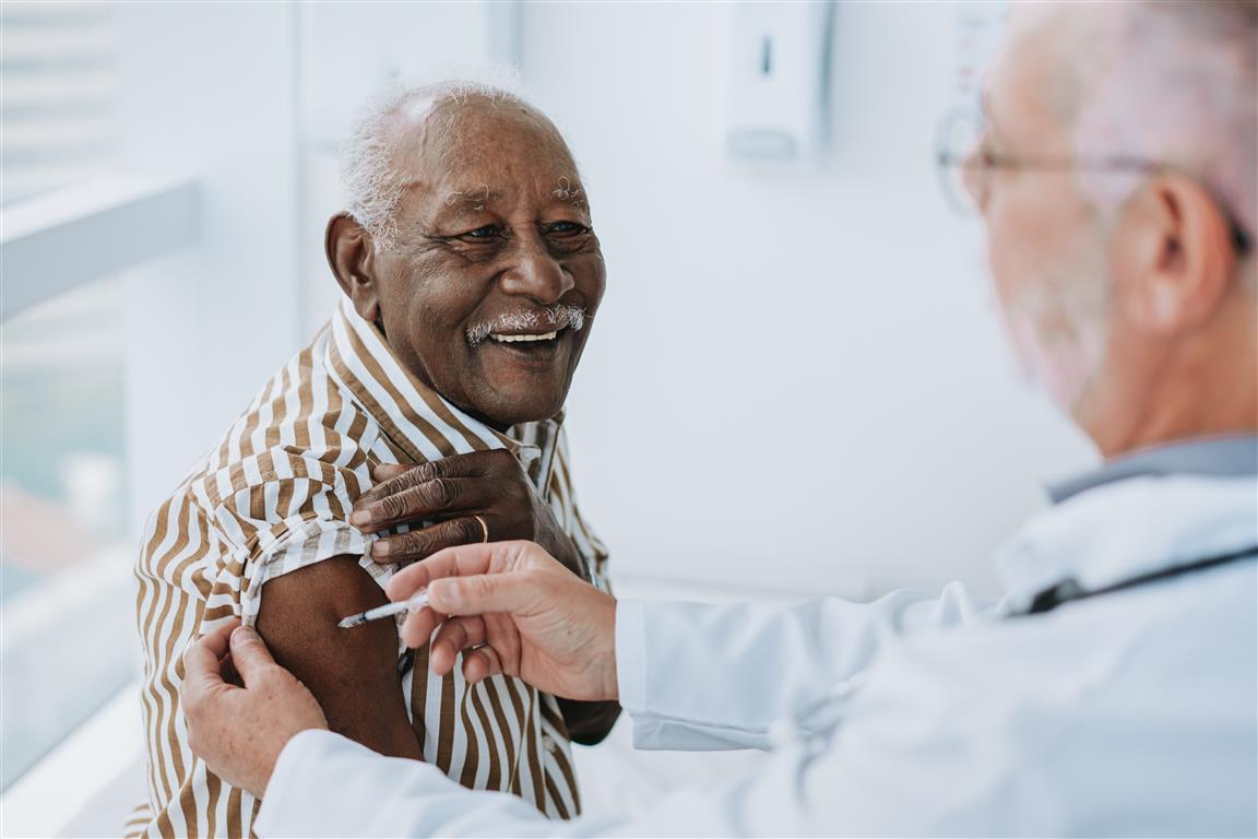 Senior gentleman getting vaccinated by pharmacist.