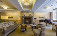 An elegant common area at the Aljoya Mercer Island retirement community, featuring a fireplace and piano for relaxation and connection in Mercer Island.