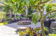 Serene outdoor garden courtyard at the Aljoya Mercer Island retirement community in Mercer Island, featuring a fire pit, comfortable seating, and lush greenery for relaxation.