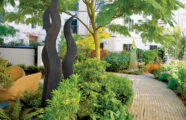 community courtyard with art sculptures, stone walking path, patio seating and interior courtyard apartments University House Issaquah premier senior housing.