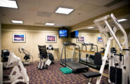 gym equipment in the fitness center which includes a TV at University House Issaquah senior living retirement community