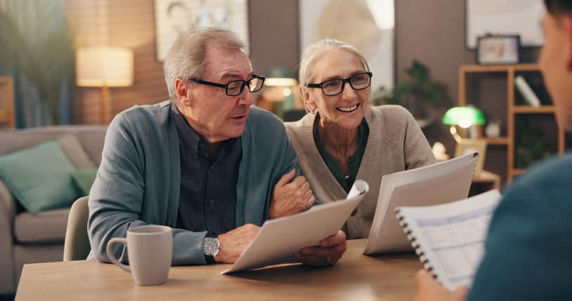 Older couple reviewing legal document with attorney