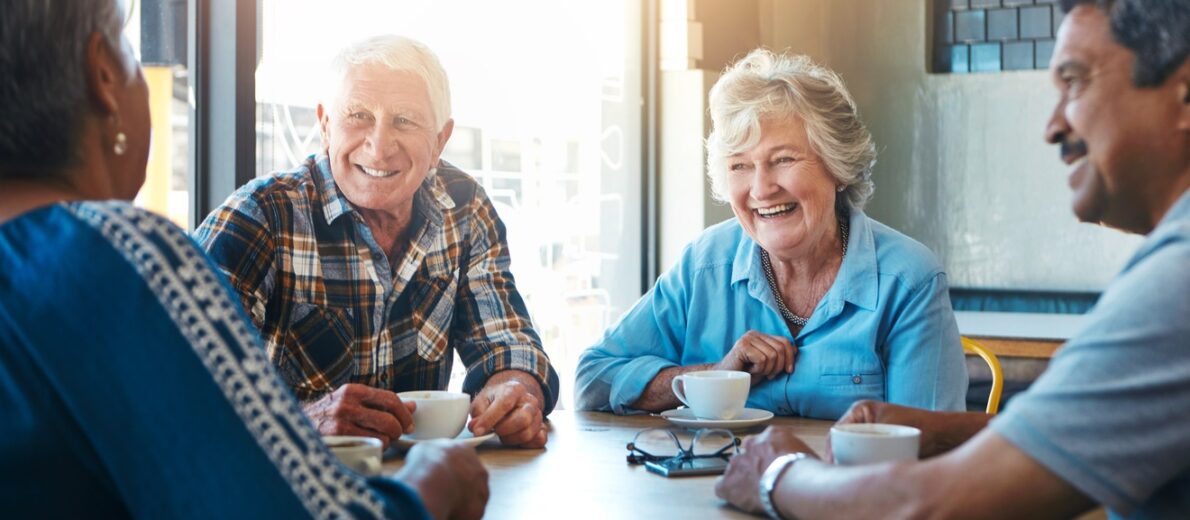 Two older couples enjoying coffee together