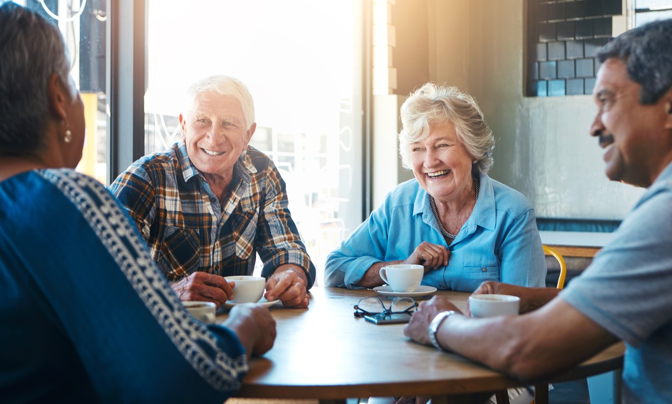 Two older couples enjoying coffee together