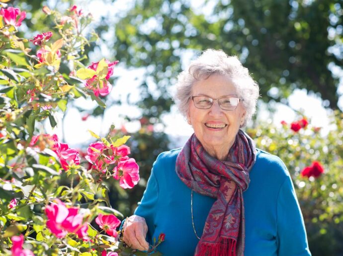 Smiling woman in blue in the rose garden