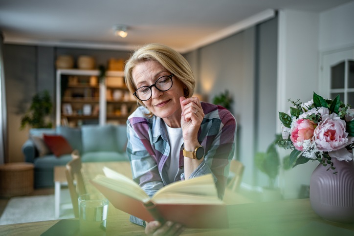 Woman reading a book with spring flowers in the background