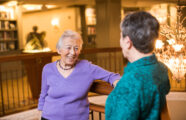 Happy senior woman enjoying friendly conversation with a neighbor in premium retirement living community located in Wallingford.