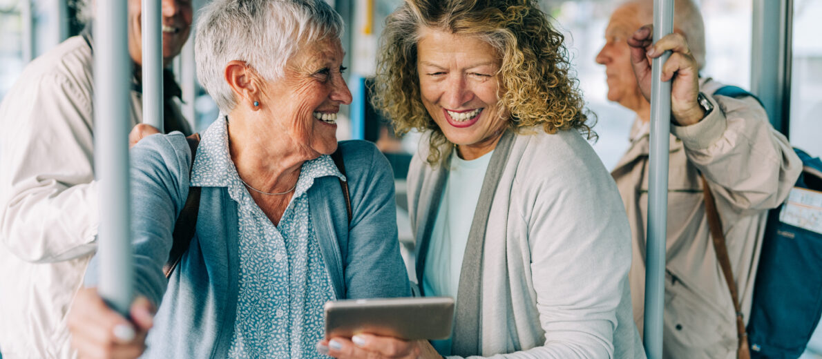 Older adults riding Seattle Metro using cellular device.