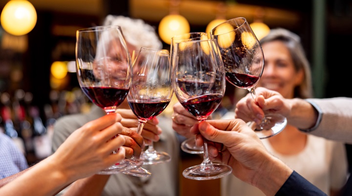 Four friends toasting with glasses of red wine